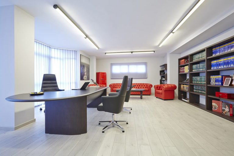 Oficina con muebles de madera y sofas rojos