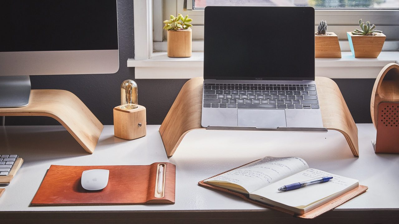 Una mesa de escritorio con dos ordenadores